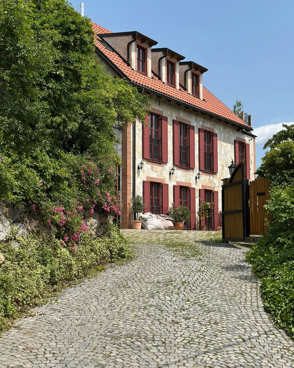 Wohnhaus mit Garten, Zufahrt und rotem Ziegeldach in Österreich